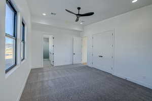 Carpeted empty room featuring a healthy amount of sunlight and ceiling fan