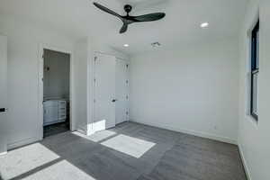 Unfurnished bedroom featuring ceiling fan, connected bathroom, and carpet flooring