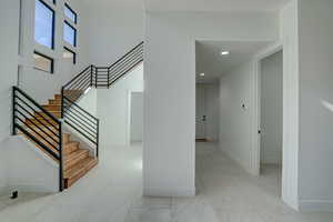 Staircase with a high ceiling and light tile floors