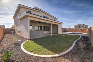 Back of property with a patio, ceiling fan, and a yard