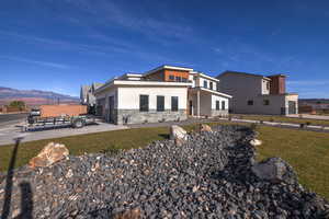 View of front of property featuring a mountain view and a front lawn