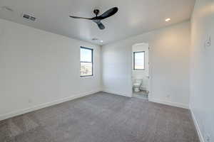 Carpeted empty room with ceiling fan and a healthy amount of sunlight