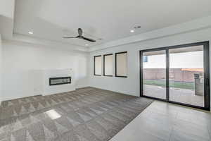 Unfurnished living room with ceiling fan and light colored carpet