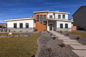 View of front of house featuring central AC and a front lawn