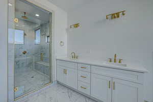 Bathroom featuring double vanity, walk in shower, and tile floors