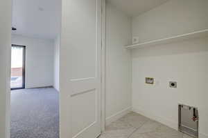 Washroom with light colored carpet, washer hookup, and hookup for an electric dryer