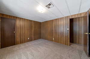 Spare room with wooden walls and carpet floors