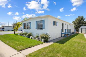 View of front of house with an outdoor structure and a front yard