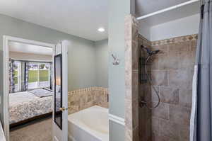 Bathroom with a textured ceiling and separate shower and tub