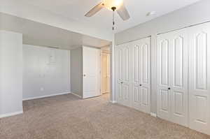 Unfurnished bedroom with multiple closets, carpet, and ceiling fan