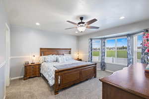 Carpeted bedroom featuring ceiling fan