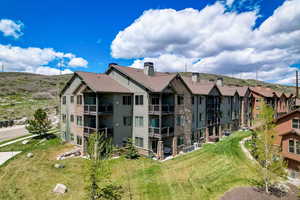 Back of property featuring a lawn and a balcony