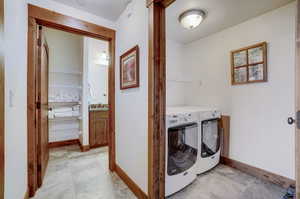 Laundry room featuring independent washer and dryer, and light tile floors