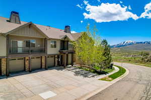 View of front of house with a garage, a mountain view, and a balcony