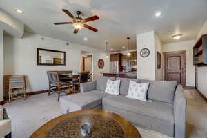 Living room with light carpet and ceiling fan