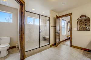 Bathroom with tile floors, an enclosed shower, and toilet