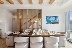 Dining space with beam ceiling and wood-type flooring