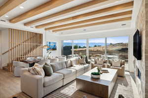 Living room featuring beam ceiling, plenty of natural light, and hardwood / wood-style floors