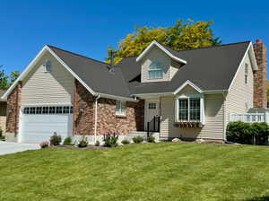 Cape cod-style house with a garage and a front lawn