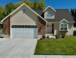 View of front facade featuring a garage and a front lawn