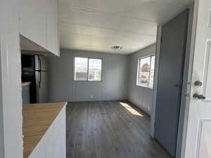 Kitchen with stainless steel refrigerator, plenty of natural light, a textured ceiling, and dark hardwood / wood-style floors