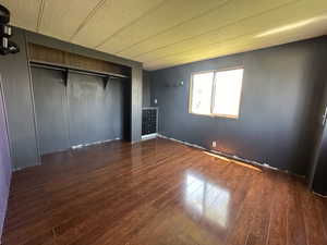 Unfurnished bedroom featuring a closet and hardwood / wood-style flooring