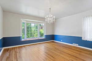 Bedroom featuring hardwood floors and a chandelier