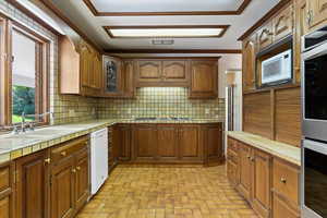 Kitchen featuring ornamental molding, backsplash, tile countertops, and stainless steel appliances