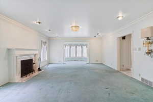 Unfurnished living room featuring light colored carpet and crown molding