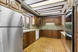 Kitchen with stainless steel appliances, tasteful backsplash, sink, and tile counters