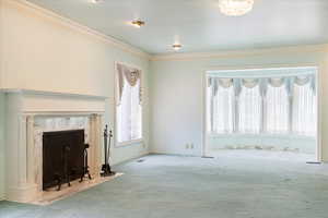 Unfurnished living room with carpet floors and crown molding