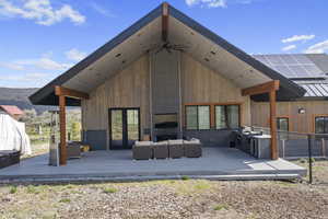 Back of house featuring outdoor lounge area and a wooden deck