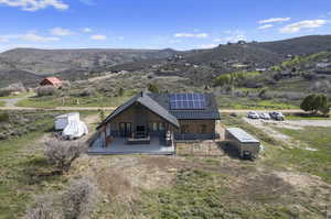 Rear view of house with a mountain view, and solar panels