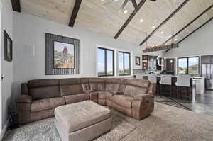 Tiled living room featuring high vaulted ceiling, ceiling fan, wood ceiling, and beam ceiling