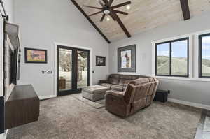 Carpeted living room featuring high vaulted ceiling, beamed ceiling, ceiling fan, and wood ceiling