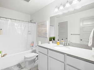 Full bathroom with oversized vanity, shower / bath combination with curtain, toilet, and tile floors