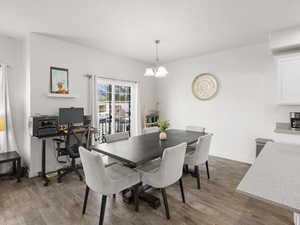 Dining area with a chandelier and hardwood / wood-style flooring