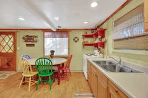 Kitchen with electric range, sink, light wood-type flooring, and beam ceiling