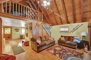 Living room featuring wooden ceiling, a wealth of natural light, hardwood / wood-style flooring, and wood walls