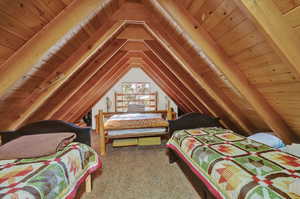 Bedroom with carpet, vaulted ceiling, and wood ceiling