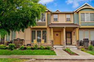 Townhome / multi-family property featuring a front yard and covered porch