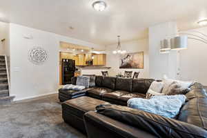 Carpeted living room with a chandelier