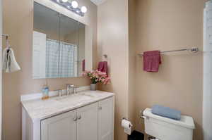 Bathroom with toilet and vanity with extensive cabinet space