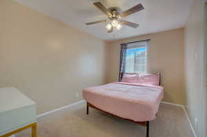 Carpeted bedroom with ceiling fan