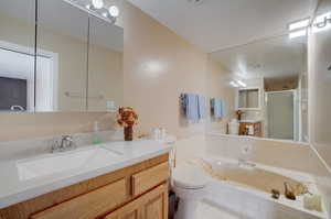 Bathroom with tile floors, tiled bath, toilet, and vanity with extensive cabinet space