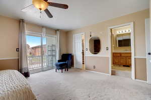 Bedroom featuring carpet flooring, access to exterior, ceiling fan, sink, and connected bathroom