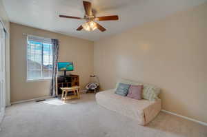 Living area with carpet and ceiling fan