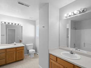 Bathroom with tile patterned floors, vanity, and toilet