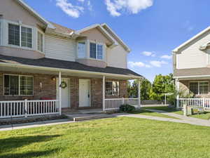 View of front of property with a front yard and covered porch