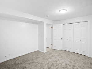 Unfurnished bedroom with a closet and light colored carpet